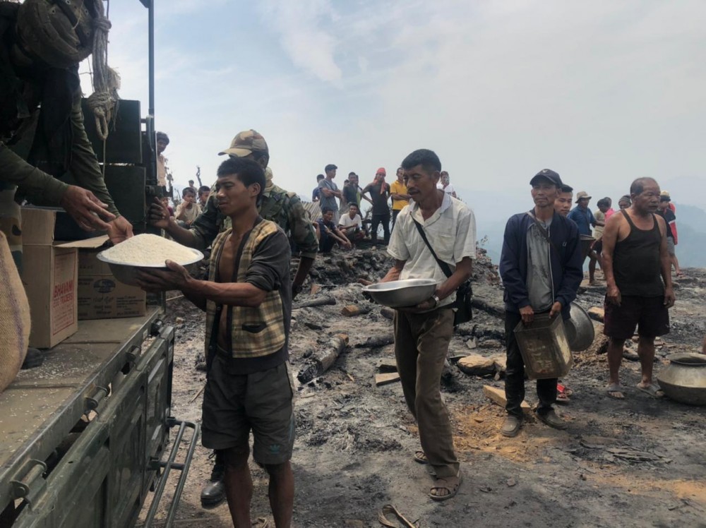 Villagers of Totok Chaiching receiving relief material from Assam Rifles on April 4.  [Photo Courtesy: HQ IGAR (N)]